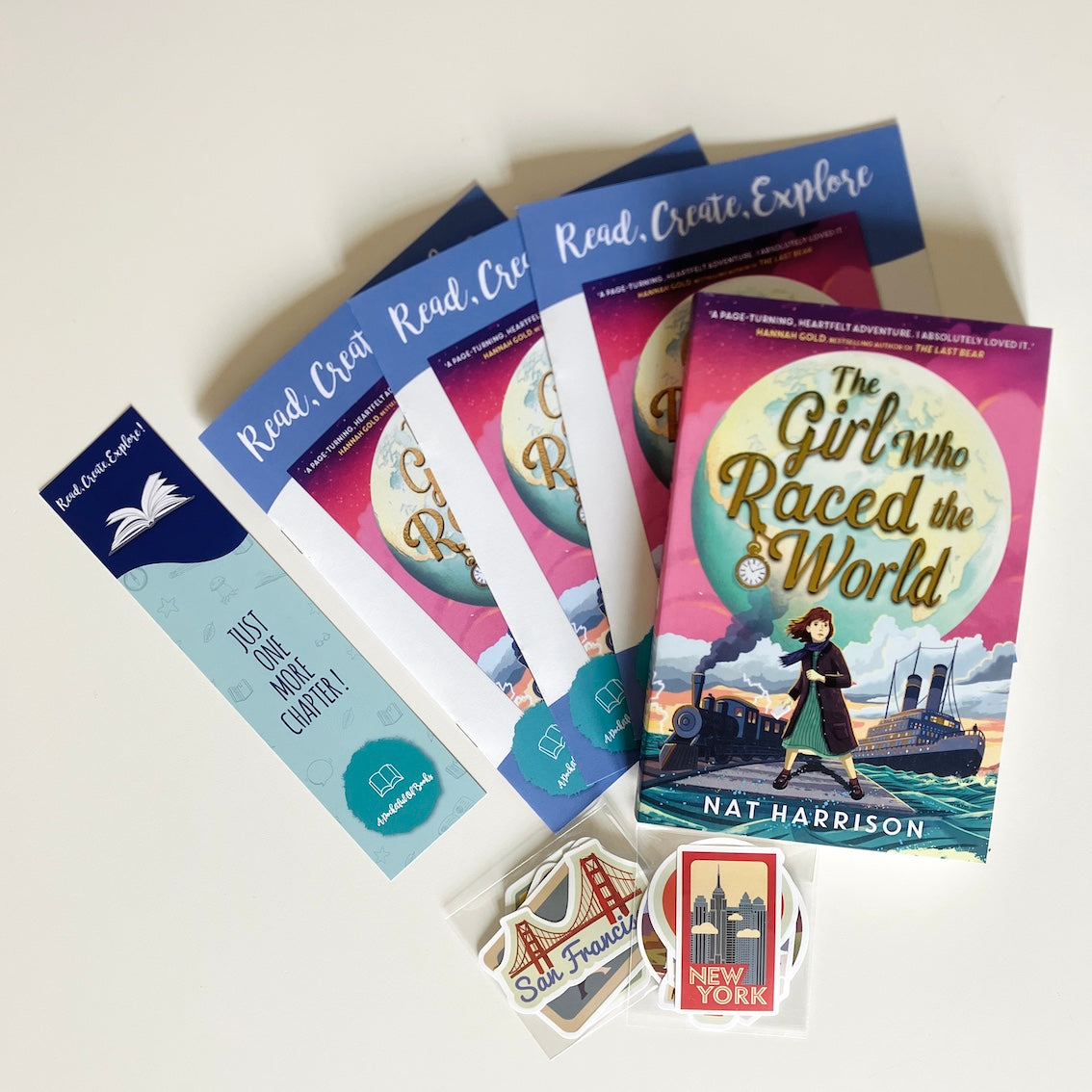 Kids monthly book subscription. Educational materials and book with 'The Girl Who Raced the World' on a white background